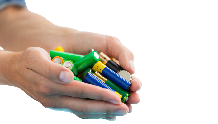 Hands holding several household batteries